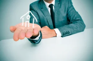 A man holding out a graphic of a house to symbol the idea of a hard money lender