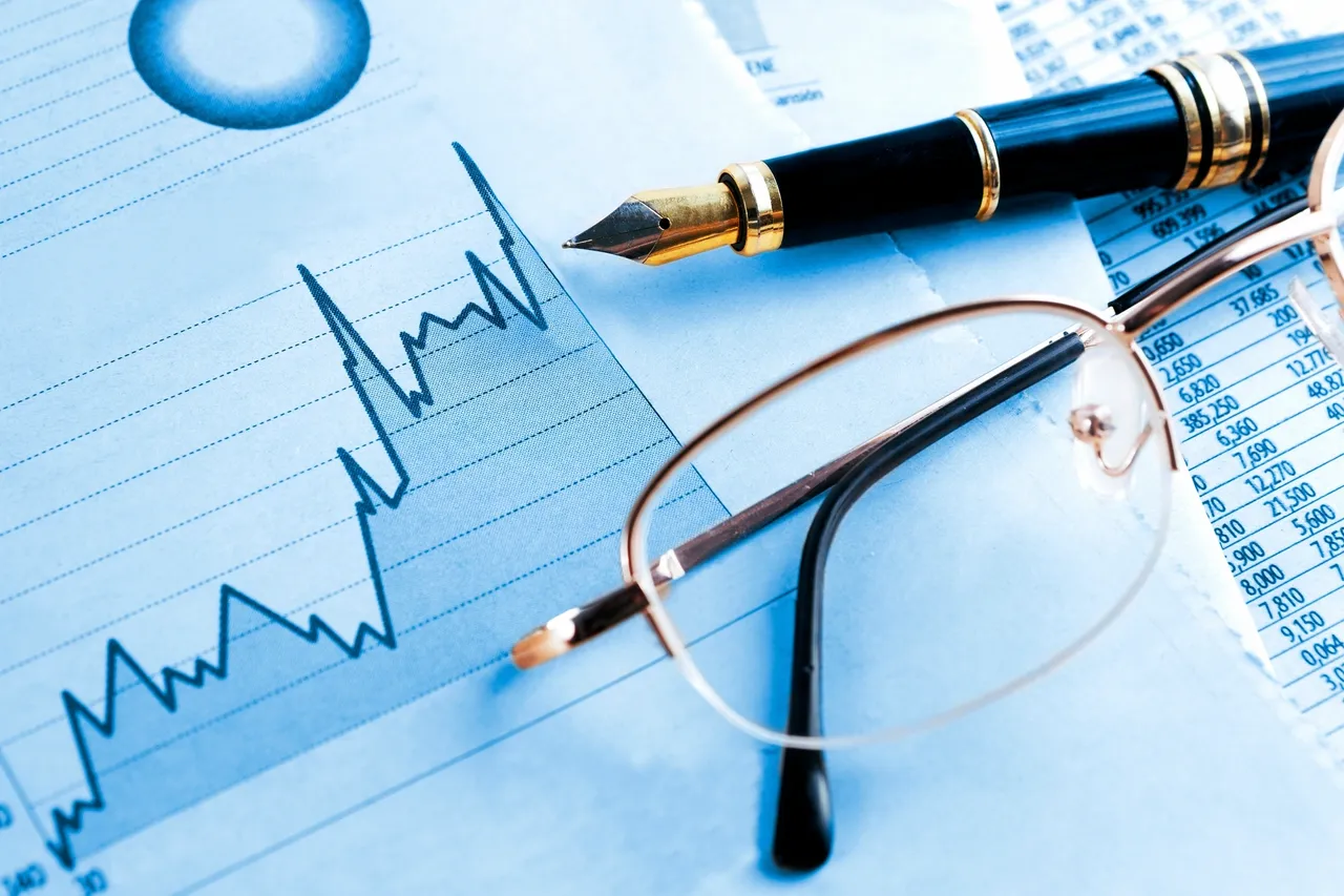 A photo of a pen, glasses and a graph indicating the changing landscape of interest rates.